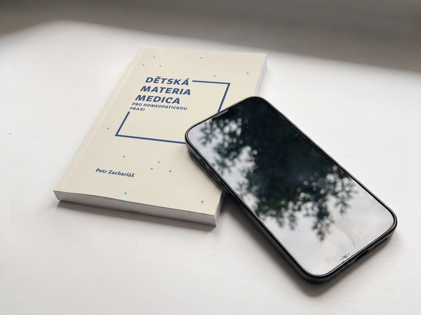 Kniha Dětská materia medica vedle mobilního telefonu pro porovnání velikosti